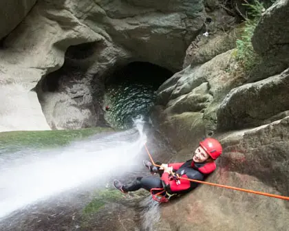 Une femme descend en rappel dans la cascade de 35 mètres au canyon d'Angon.