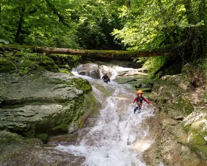 Un enfant fait un toboggan dans l'eau de la randonnée aquatique.